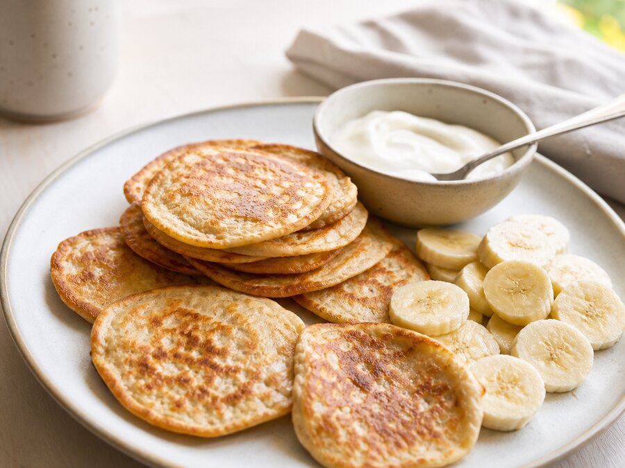 Bananpannkaka med bananskivor och yoghurt på en ljus tallrik